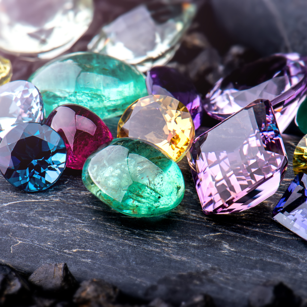 A vibrant assortment of colorful, polished gemstones displayed on a slate surface.